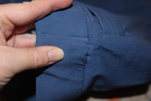 See the stitching between my fingers? That’s tacking the elastic down. It helps make sure the stretch is even and helps the elastic not to fold in half.