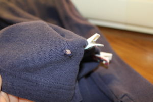 Navy blue polo with a hole near the hem