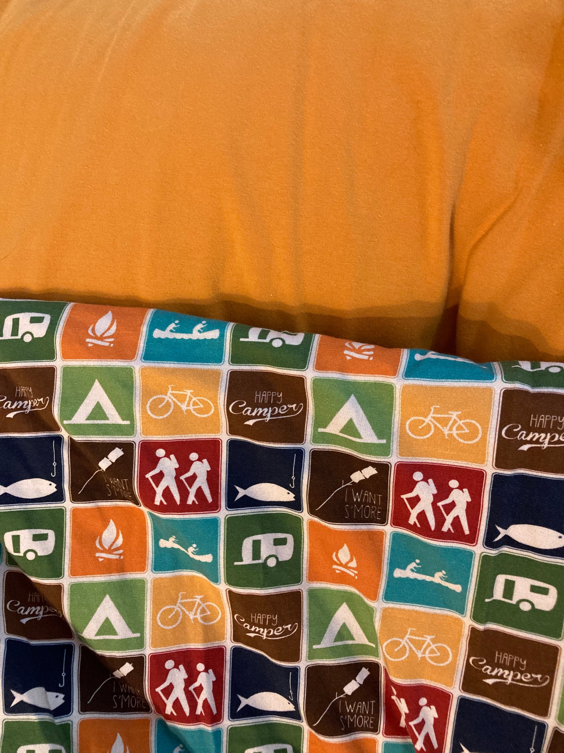 camping symbols fabric paired with mustard yellow.  Camping symbols include hikers, s'mores, bike, tent, camper, fishing, and Happy Camper text